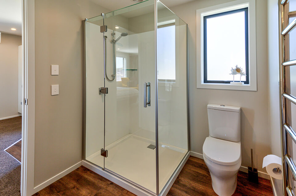 Bathroom setting with a glass-doored shower, toilet